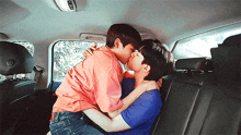 two men kissing in the back of a car