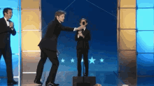 Bradley James Helping Out Jacob Tremblay During Acceptance Speech GIF - Acceptance Speech Jacob Tremblay Best Young Actor GIFs