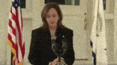 a woman stands in front of a podium that says " of the " on it