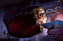 a large piece of meat is being held by a hand
