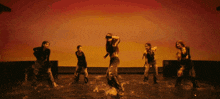 a group of young women are dancing on a stage and one of them is holding a piece of paper in her hand