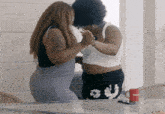two women standing next to each other with a red mug that says budlight on it