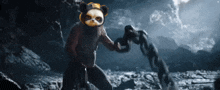 a panda bear holding a chain in a cave