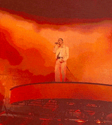 a man is singing into a microphone on a stage