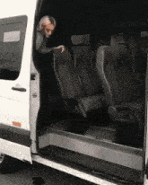 a woman is getting out of a white van with the door open