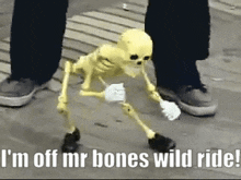 a yellow skeleton is walking on the ground next to a person .