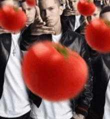 a group of men are standing next to each other holding tomatoes in their hands .