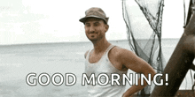 a man in a hat is standing on a boat in the ocean and says good morning .