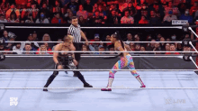 two wrestlers are fighting in a wrestling ring with a referee in the corner