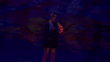 a woman with blonde hair is standing in front of a painting