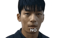 a young man is making a funny face with the word no written on his mouth .