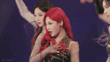 a woman with red hair is standing next to another woman on a stage .