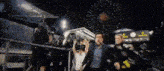 a group of people are standing in front of a fireworks display holding trophies .