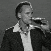 a man in a suit is drinking a coca cola bottle