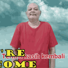 a man in a red shirt is standing in front of a sign that says " terima kasih kembali come "