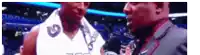 a man in a suit is talking to a basketball player