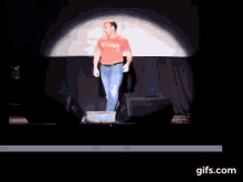 a man in a red canada shirt stands on a stage