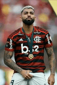 a man with a beard is wearing a medal around his neck while standing on a field .