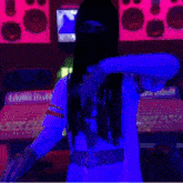 a man wearing a ski mask is standing in front of a computer