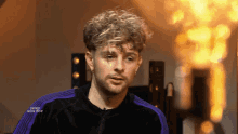 a man in a purple and black jacket with the words swiss new pop on the bottom right