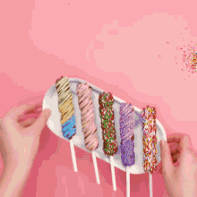 four chocolate covered marshmallows with sprinkles on a plate