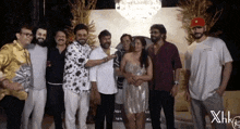 a group of people posing for a picture with xhk written on the bottom left