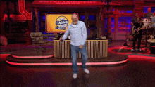 a man is dancing on a stage in front of a sign that says miller lite