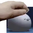 a hand is reaching out towards a white object with a face on it .