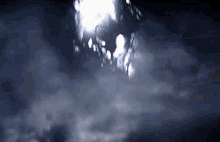 a dark cloudy sky with a few lights visible