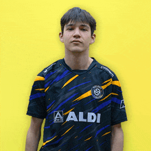 a man wearing a black and yellow shirt with aldi on it