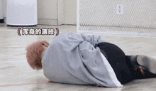 a person laying on the floor with chinese writing on the wall
