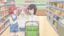 three anime girls are standing in a grocery store with a green basket