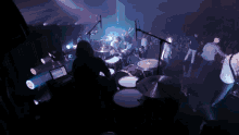 a drummer playing drums in front of a crowd of people