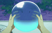 a person is holding a blue sphere with a face on it