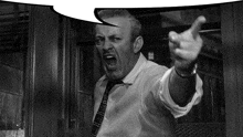a black and white photo of a man pointing with a speech bubble above him