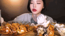 a woman is eating a bowl of food with her eyes closed