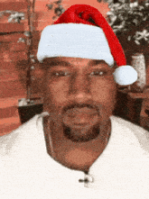 a man with a santa hat on his head looks at the camera