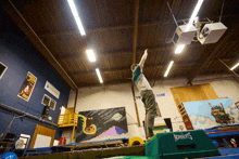 a boy is doing a trick on a trampoline in a gym that says roberts