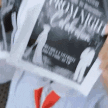a person is holding a piece of paper with a picture of a man and woman on it .