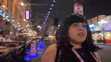 a woman stands in front of a street sign that says no parking