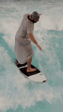 a man riding a wave on a surfboard wearing a swim cap
