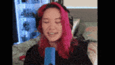 a girl with pink hair is wearing headphones