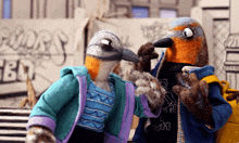 two stuffed birds are standing next to each other in front of a sign that says ' birds '