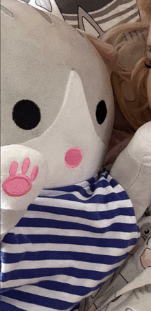 a stuffed animal has a pink paw print on it