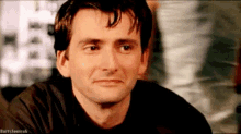 a man in a black shirt is making a funny face .