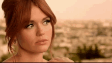 a woman with red hair is looking up at the sky .