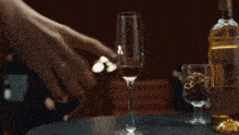 a woman in a black dress is holding a martini while another woman sits at a table