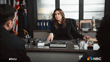 a woman is sitting at a desk with a name plate that says captain