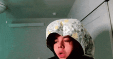 a person wearing a hooded shirt with a floral pattern