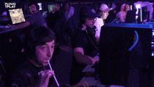 a man drinking from a straw while playing a video game with the words " ploug play " in the corner